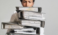 A man carrying a stack of work files